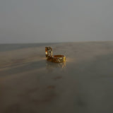 image of gold hoop earrings on a marble table against a white backdrop
