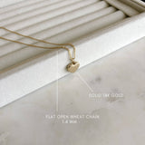 image of a gold heart locket on top of a jewelry ring tray with the descriptions of a solid 14k gold chain and the type of chain
