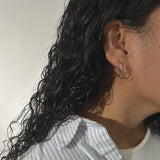 image of woman with two golden hoop earrings