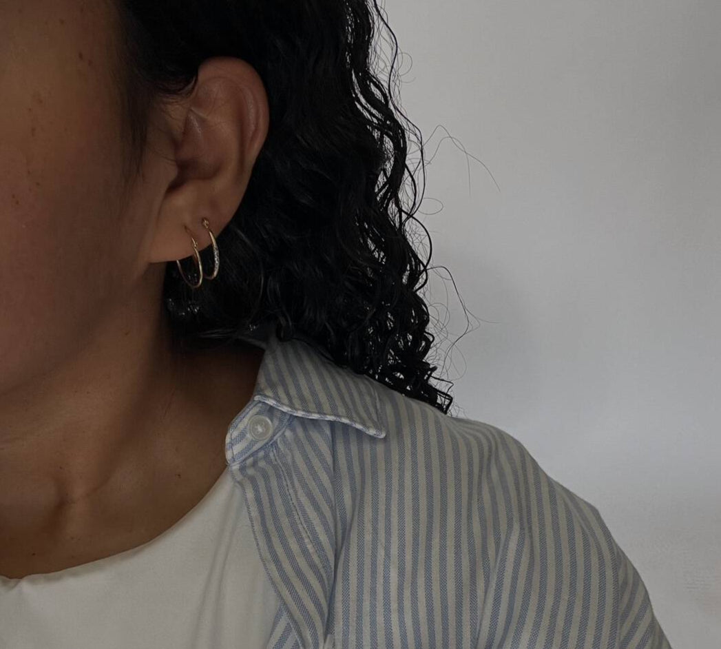 image of woman with two golden hoop earrings selfie
