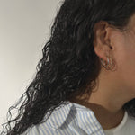 image of woman with two golden hoop earrings