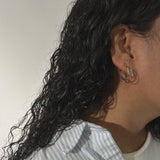 image of woman with two golden hoop earrings