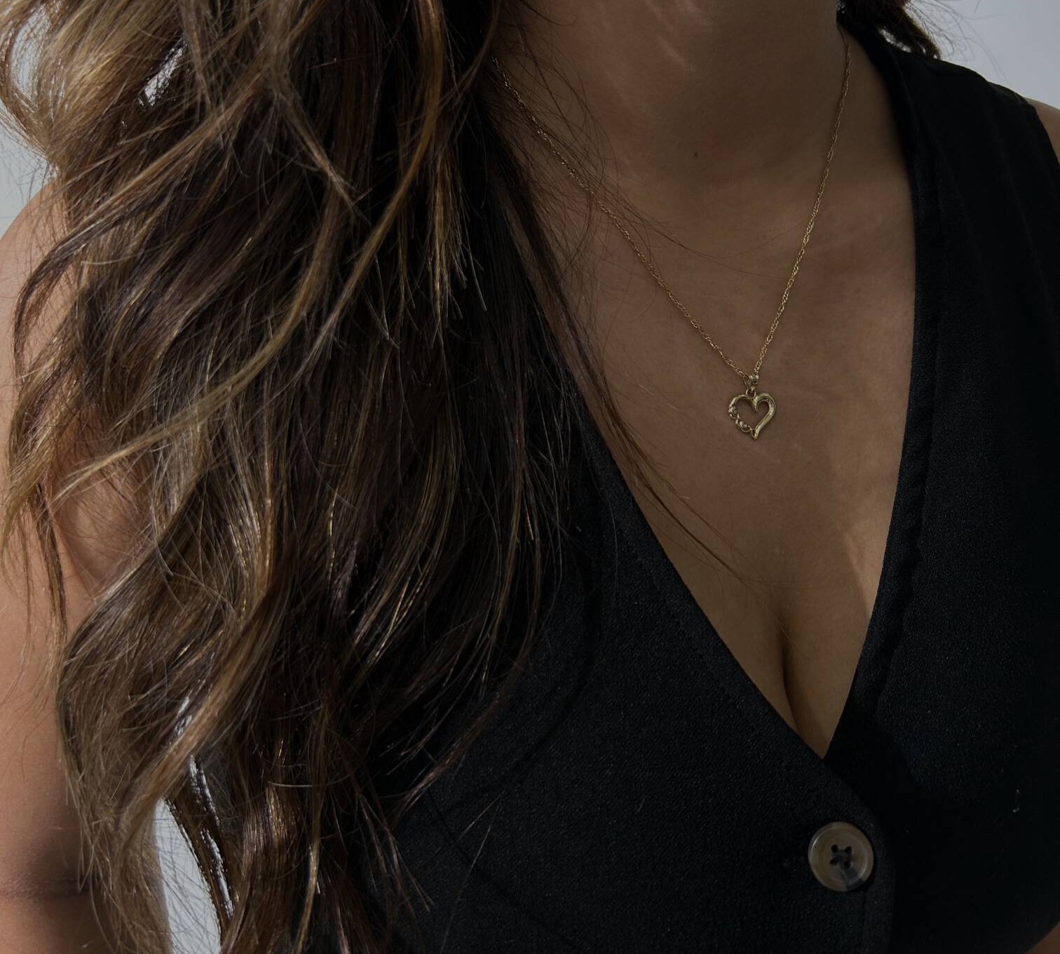 image of a woman wearing a gold heart necklace