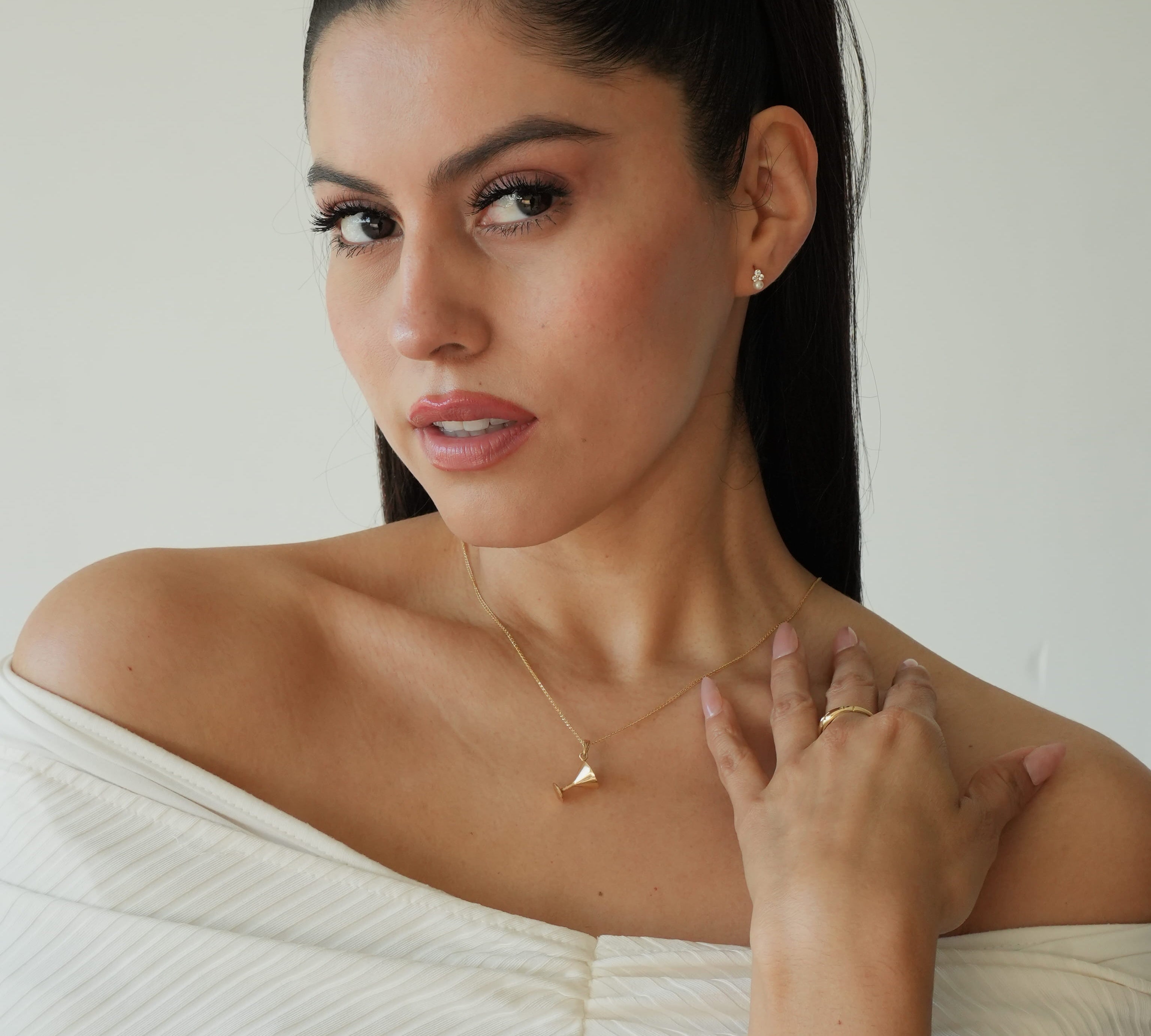Woman wearing a white off-shoulder top with a plain background