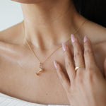 Woman wearing a delicate gold necklace with a blurred background