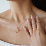 Woman wearing a delicate gold necklace with a blurred background