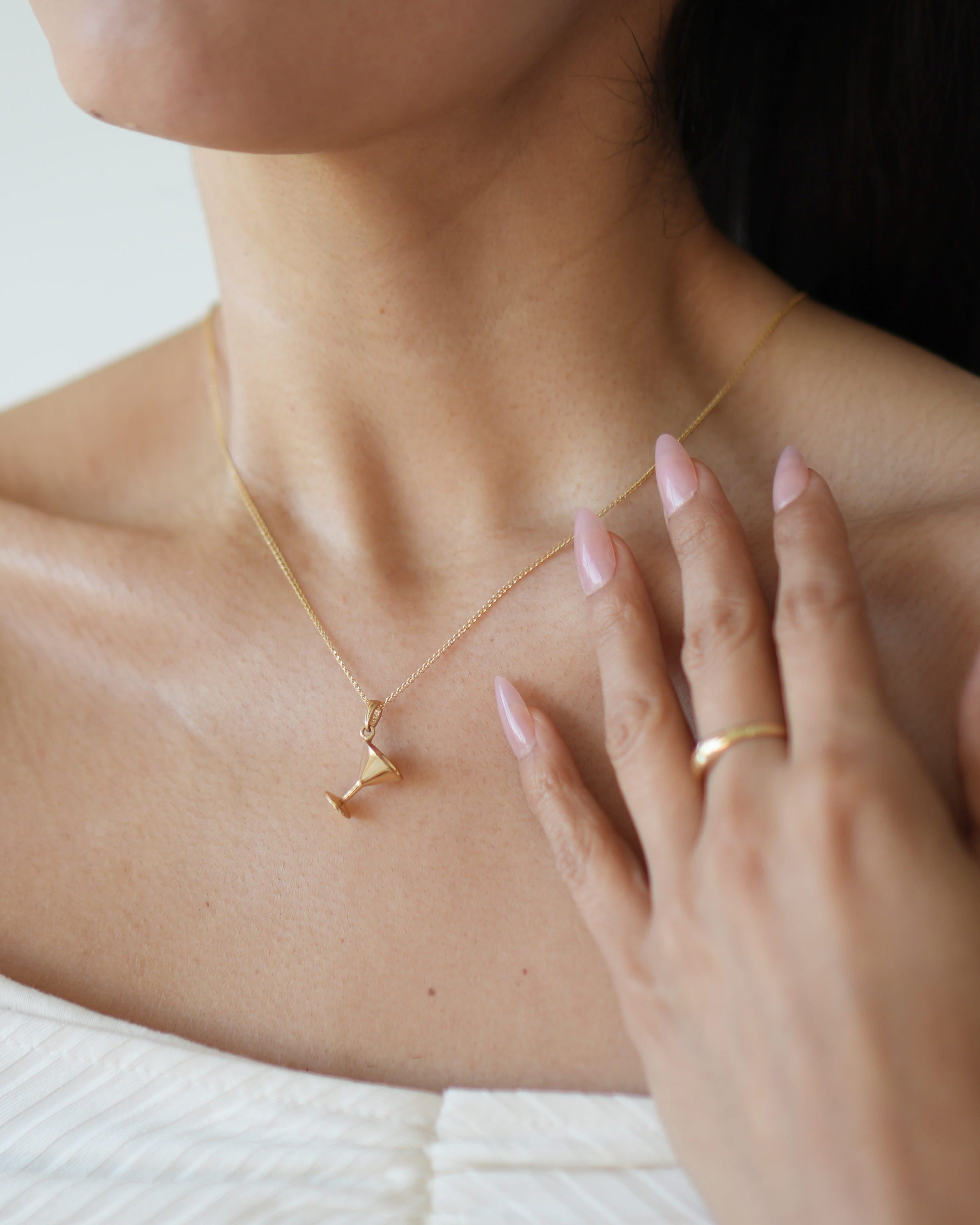 Woman wearing a delicate gold necklace with a blurred background