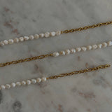 image of three pearl chain bracelets on a marble table