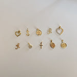 image of multiple gold charm pendants on a white backdrop