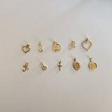 image of multiple gold charm pendants on a white backdrop
