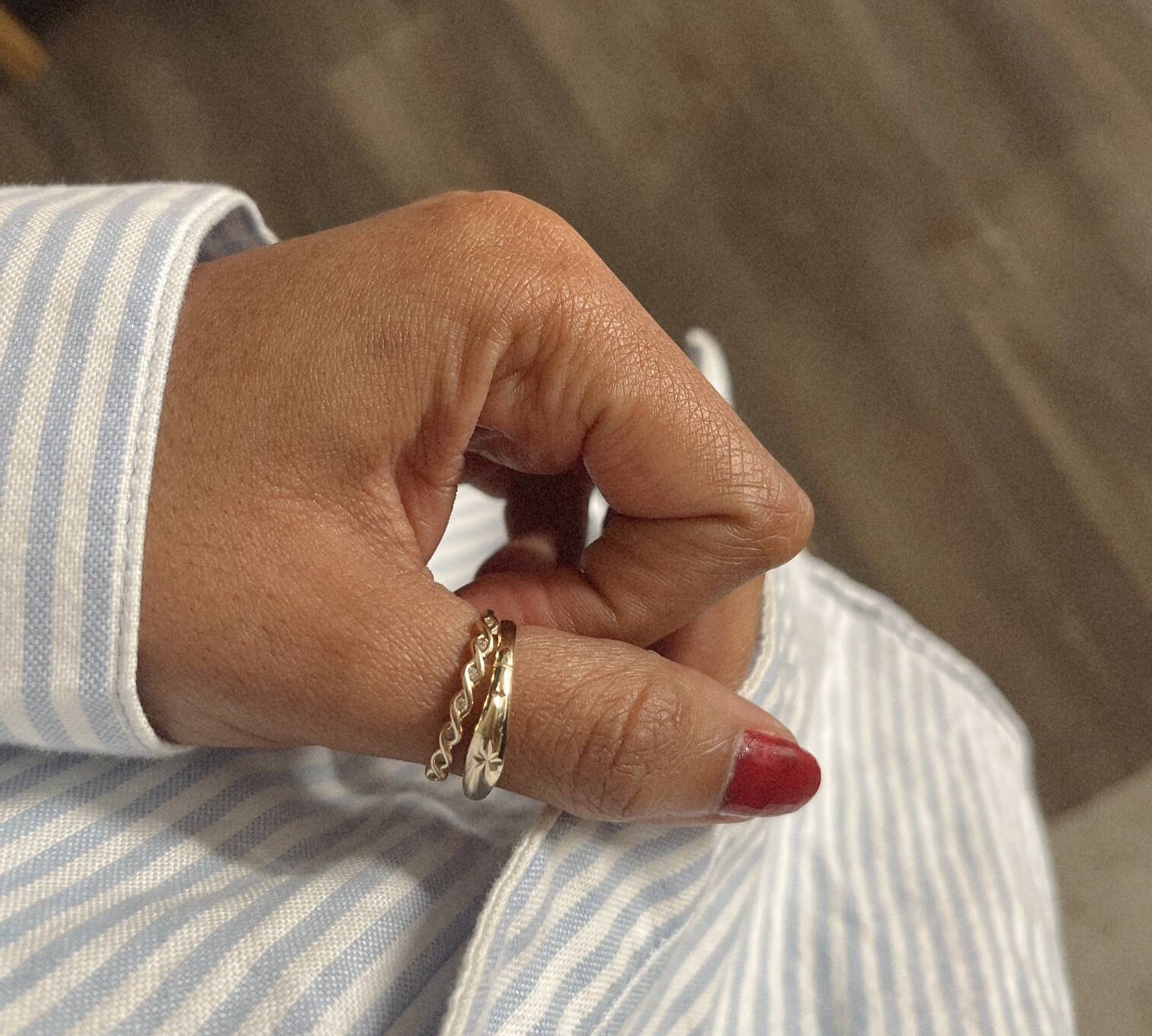 image of a womans hands with two gold rings in her thumbs