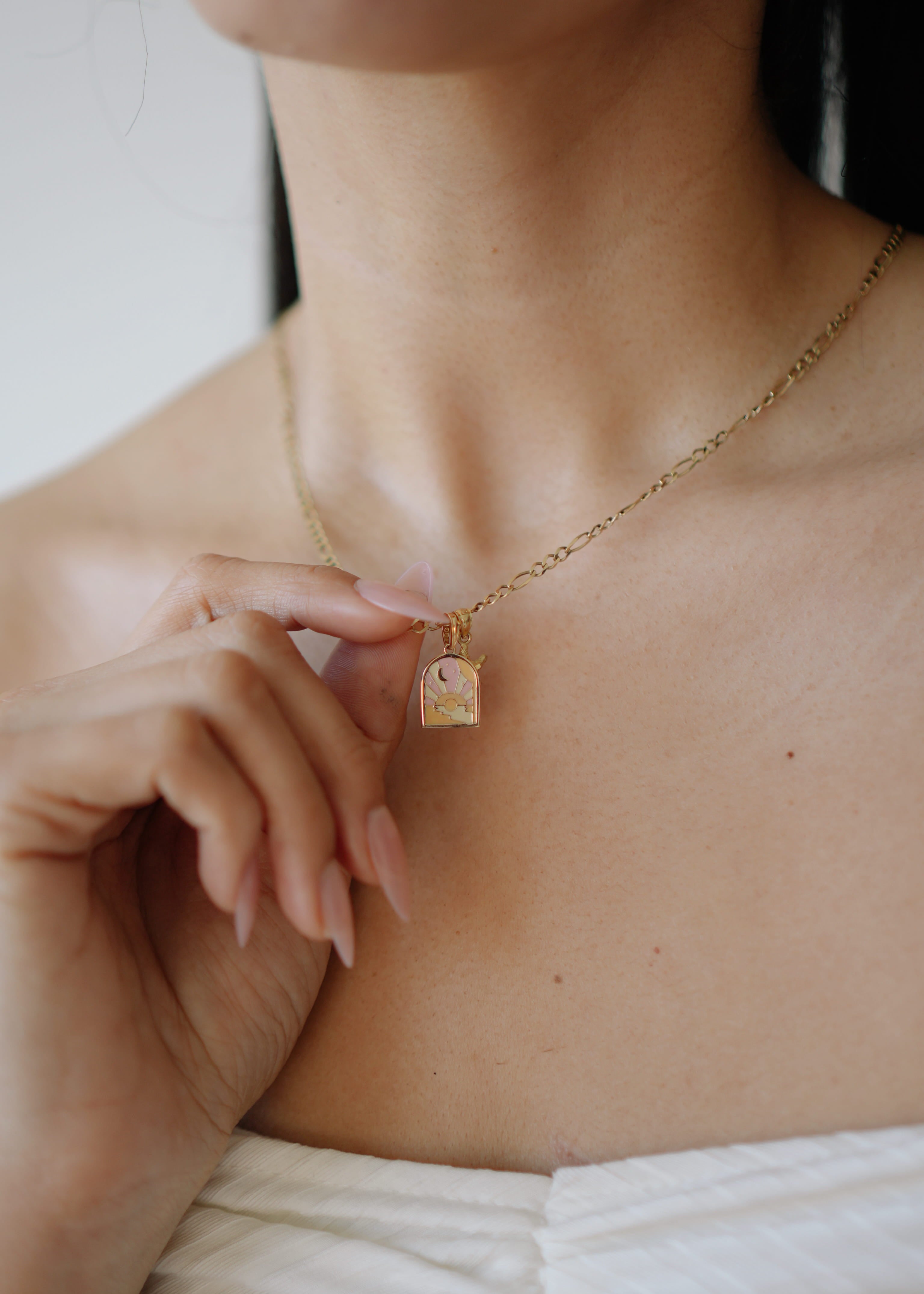 Necklace with a small square pendant worn by a person