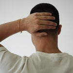 Person with hand on head against a plain background