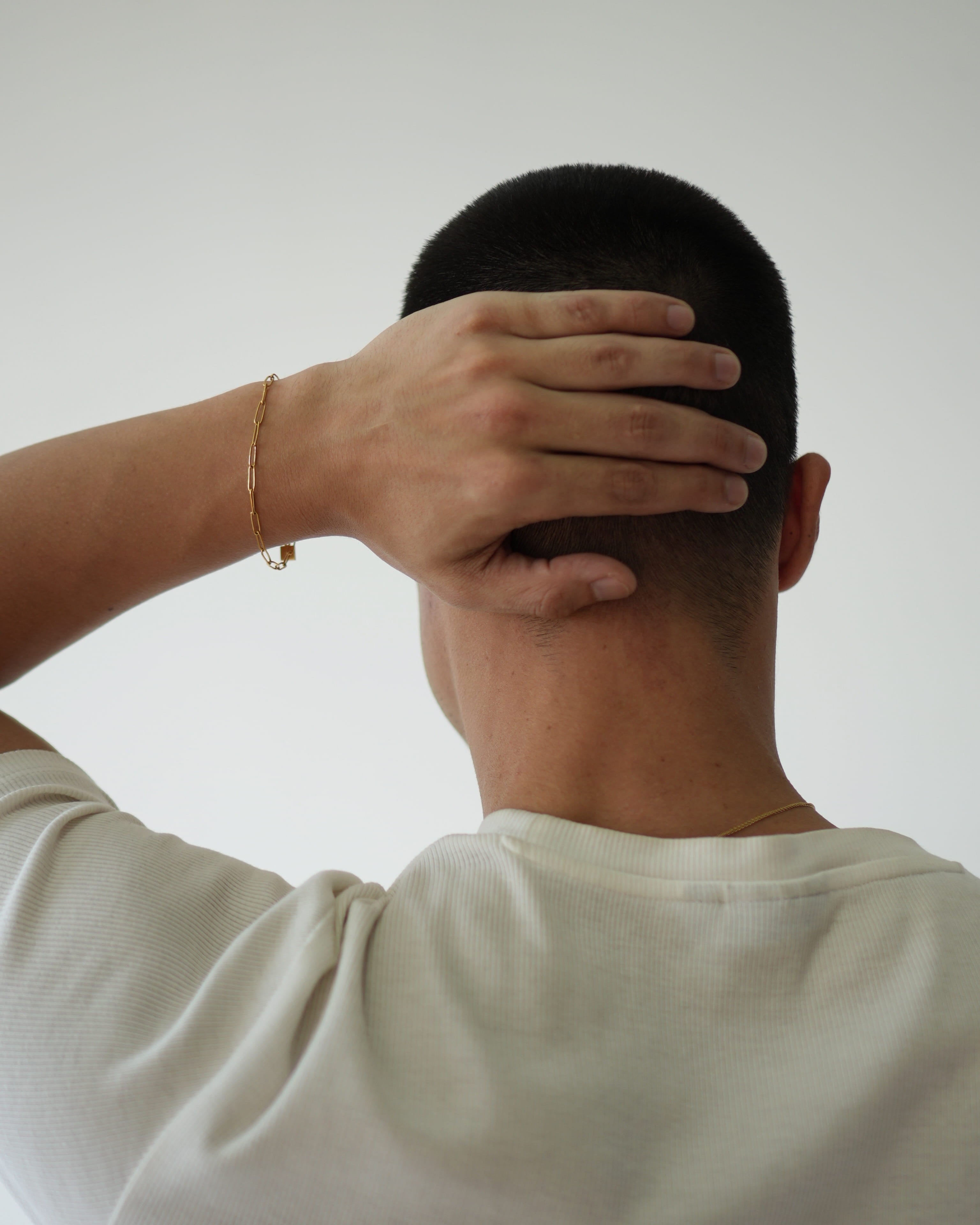 Person with hand on head against a plain background