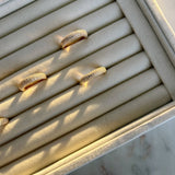 image of four pave gold rings on a ring tray holder on top of a marble floor 