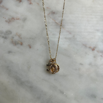 image of pendant charms on a necklace against a marble backdrop
