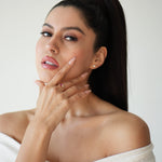 Woman in a white off-shoulder top with a plain background