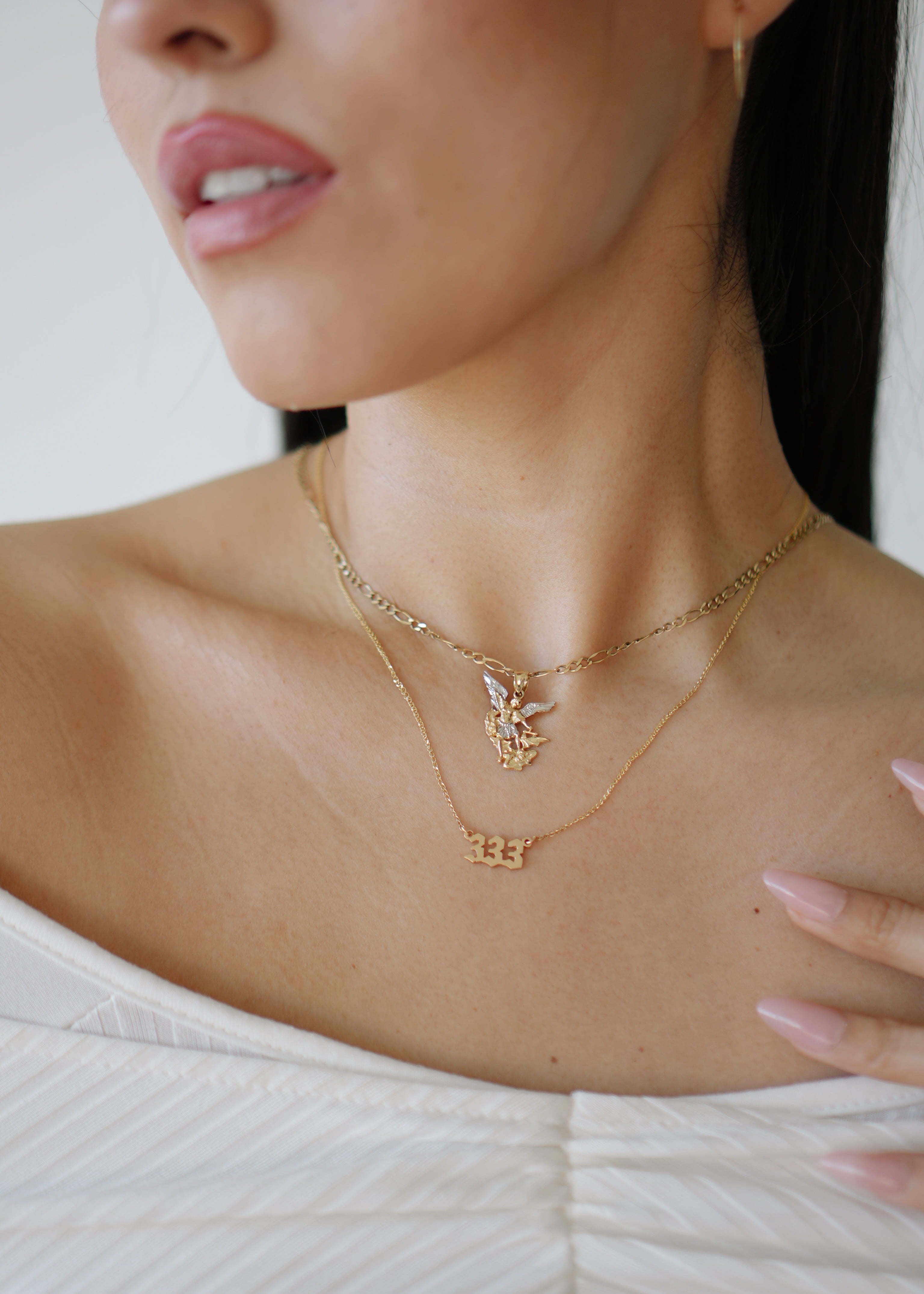 Close-up of a woman wearing gold necklaces with a blurred background
