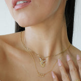 Close-up of a woman wearing gold necklaces and a ring on a white background