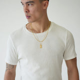 Man wearing a plain white t-shirt and black pants against a light gray background